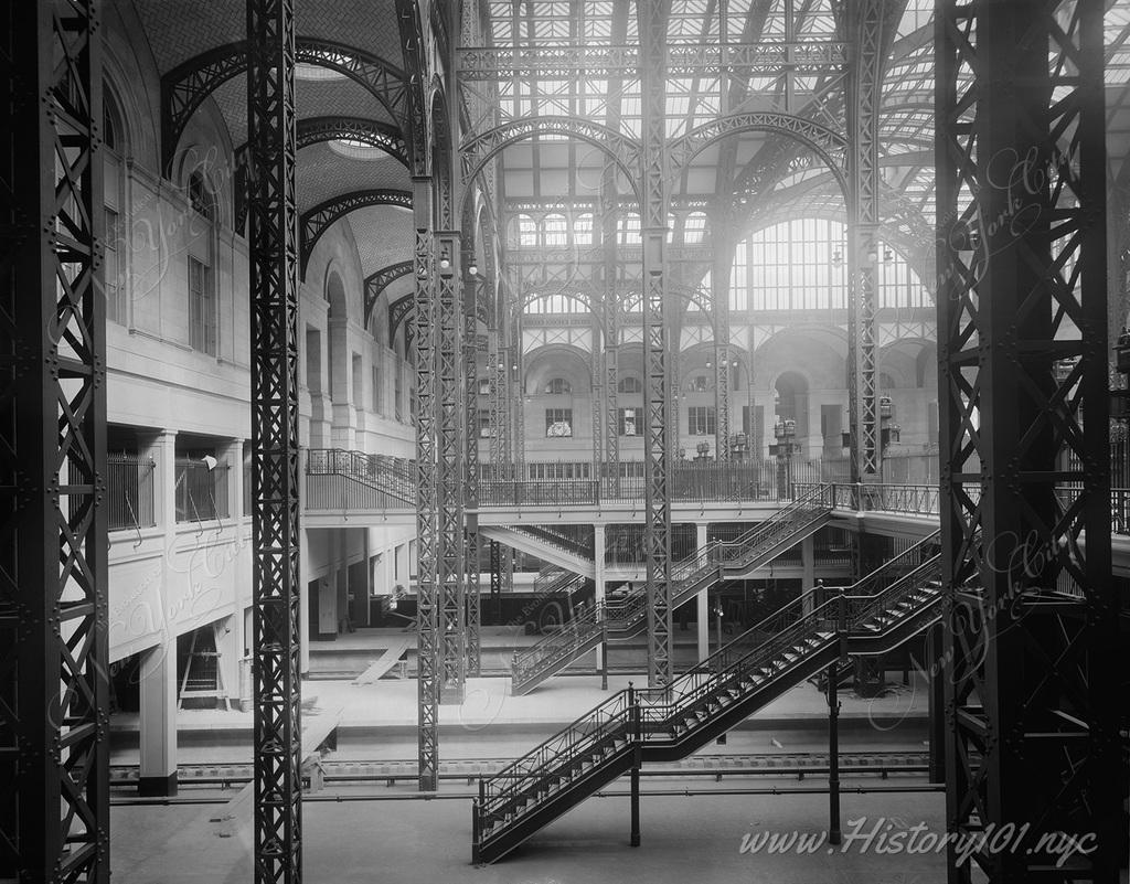 Interior view of Penn Station's concourses, drenched by the sun due to the greenhouse-inspired design of its glass ceiling.