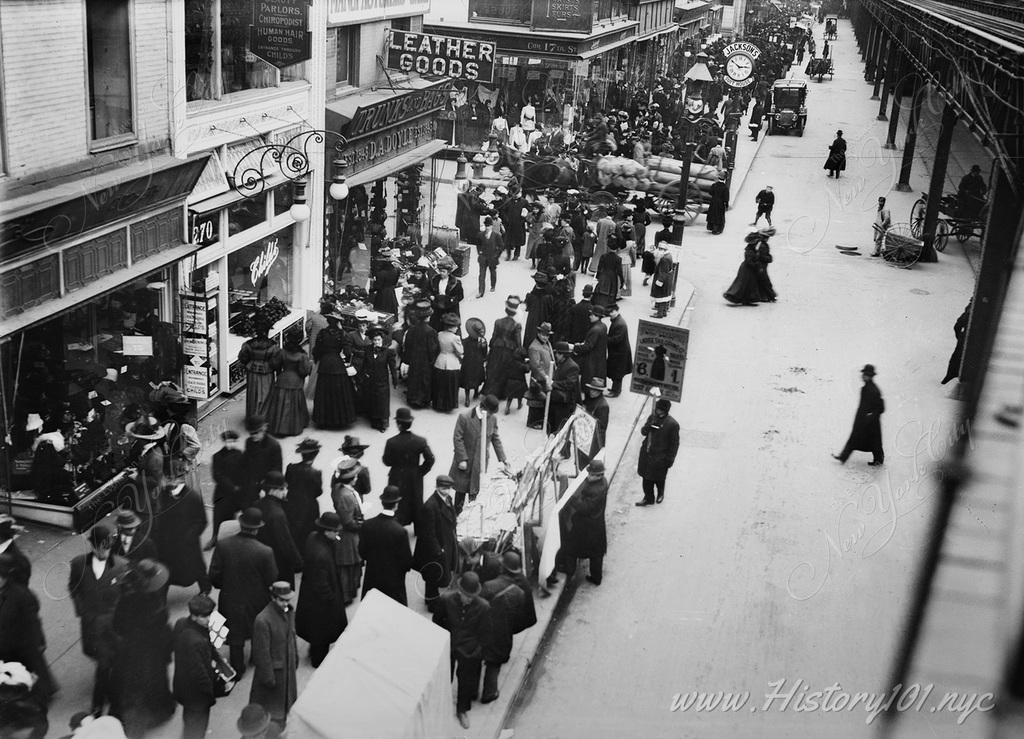 Overhead photograph shows Sixth Avenue packed with pedestrians and shoppers along the path of the elevated train.