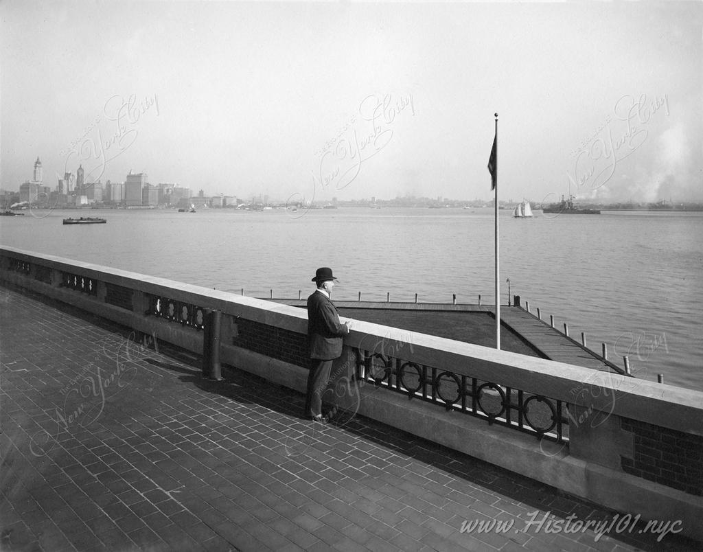 A derby-topped gentleman observing the harbor form the observation roof on one wing of the Immigration Station.