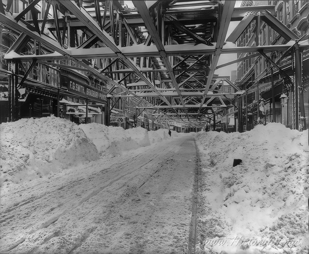 Photograph shows a view of Fulton Street toward the ferry after snow plows have cleared a path through the blizzard.