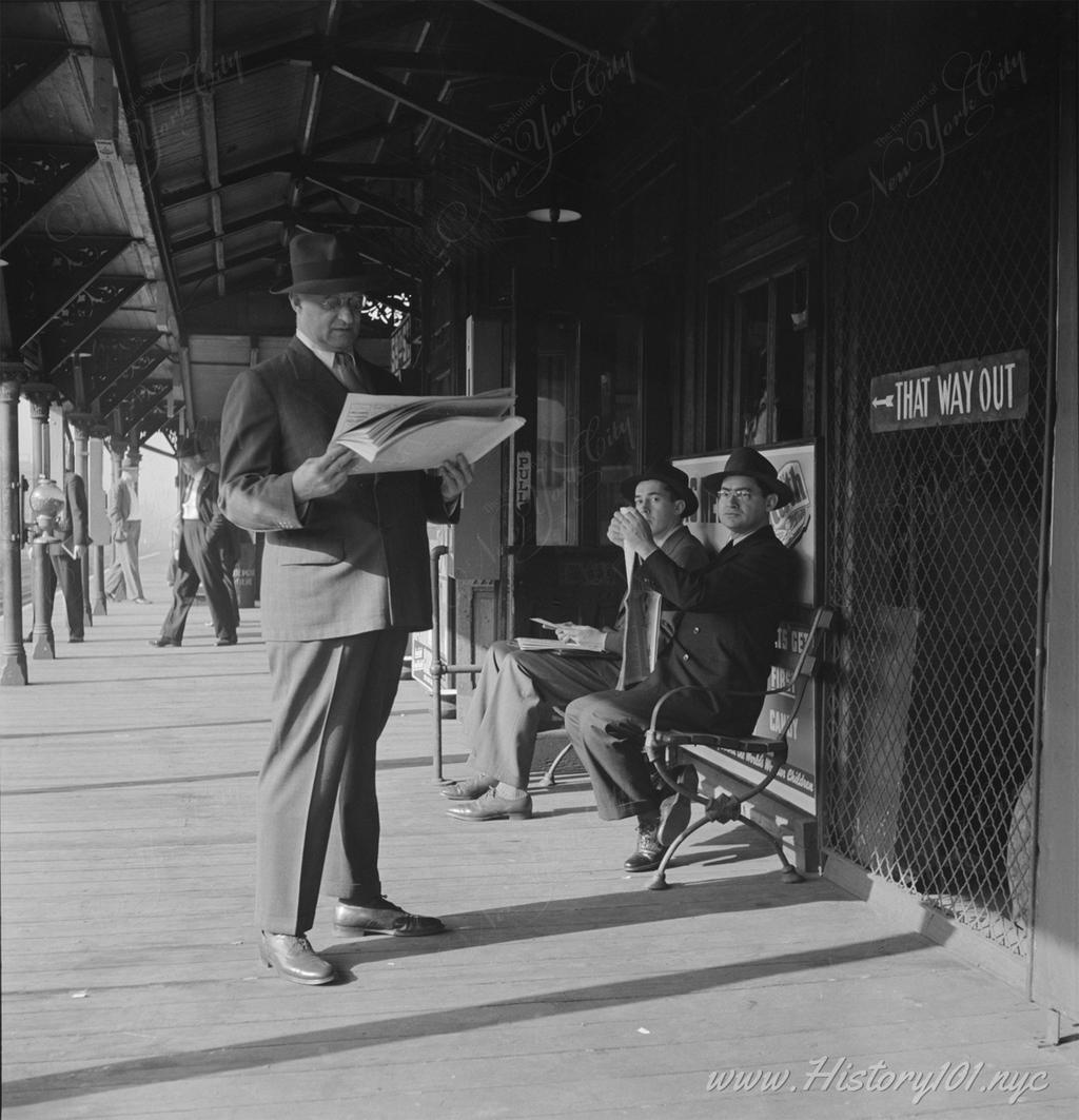 Photograph of midtown commuters waiting at a platform for the Third Avenue elevated train.