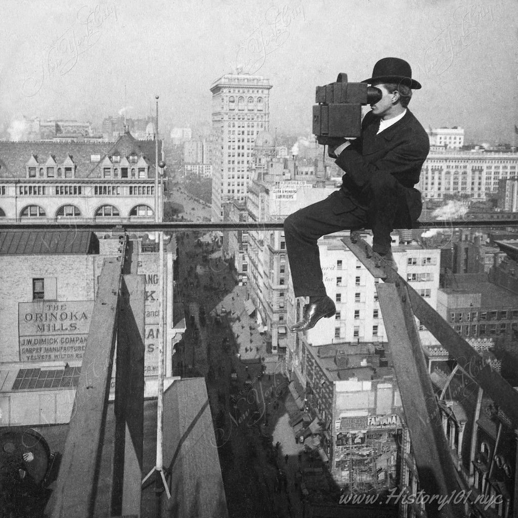 A photographer shooting the skyline 18 stories above pavement of Fifth Avenue, as he sits on a thin support beam of a skyscraper under construction.