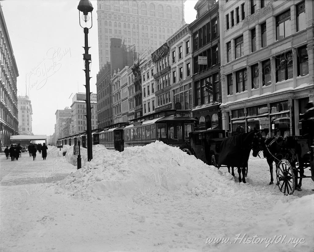 Photograph looking east from Sixth Avenue, on 23rd Street. Rows of carriages are blockaded from the January 24th storm which covered the city in 11" of snow.