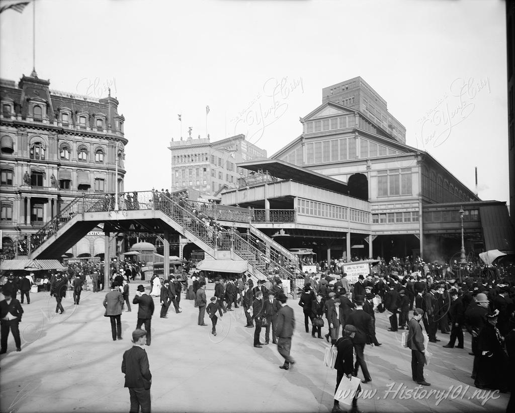 Manhattan commuters flock near the entrance to the pedestrian walkway and elevated train station of the Brooklyn Bridge.