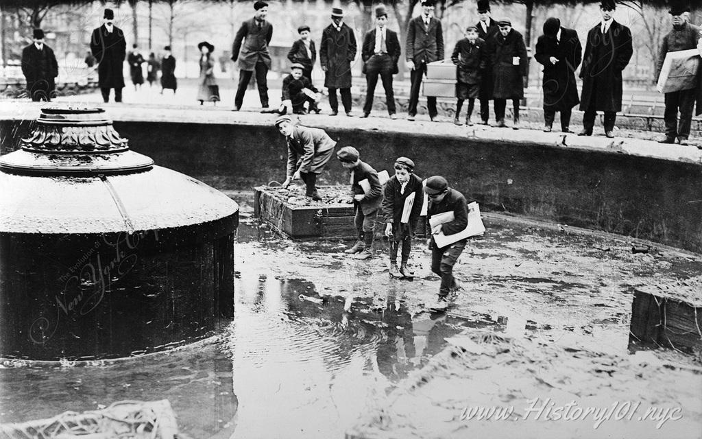 Children trying to catch goldfish in the remaining puddles of Union Square's Fountain.