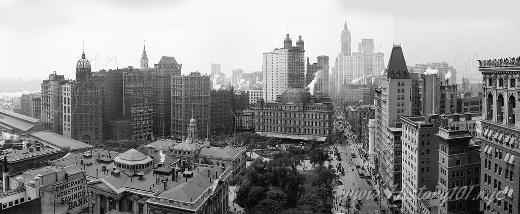 A panoramic photograph of Manhattan's downtown skyline, including City Hall and the Singer Building.
