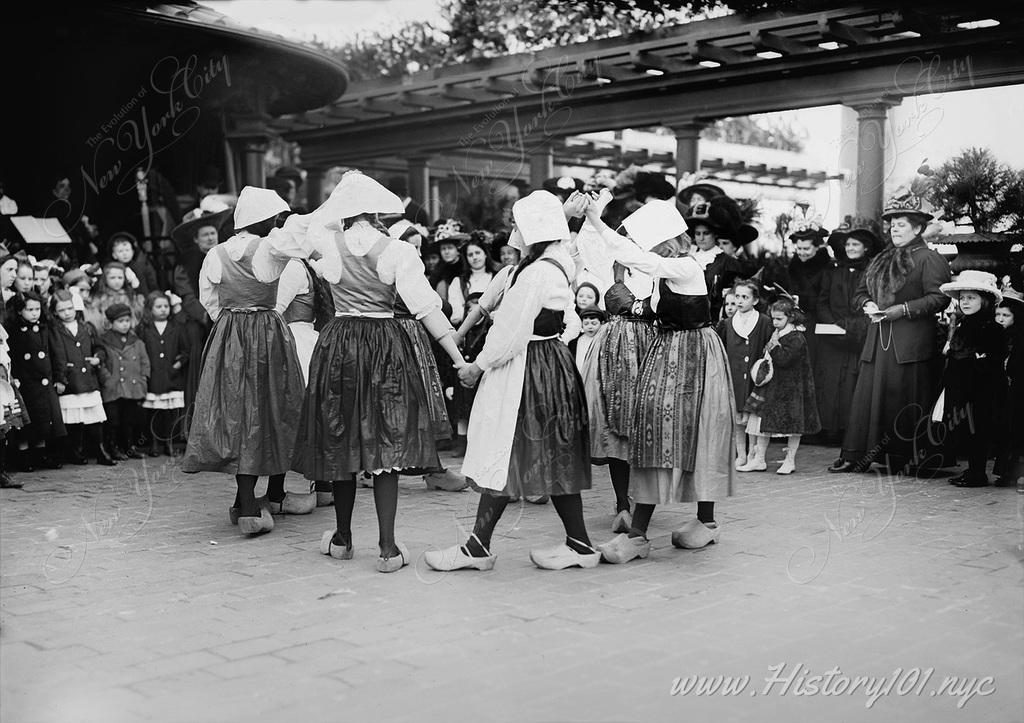 A group of young dancers in traditional Dutch attire dance at the rooftop terrace of The Waldorf Astoria.