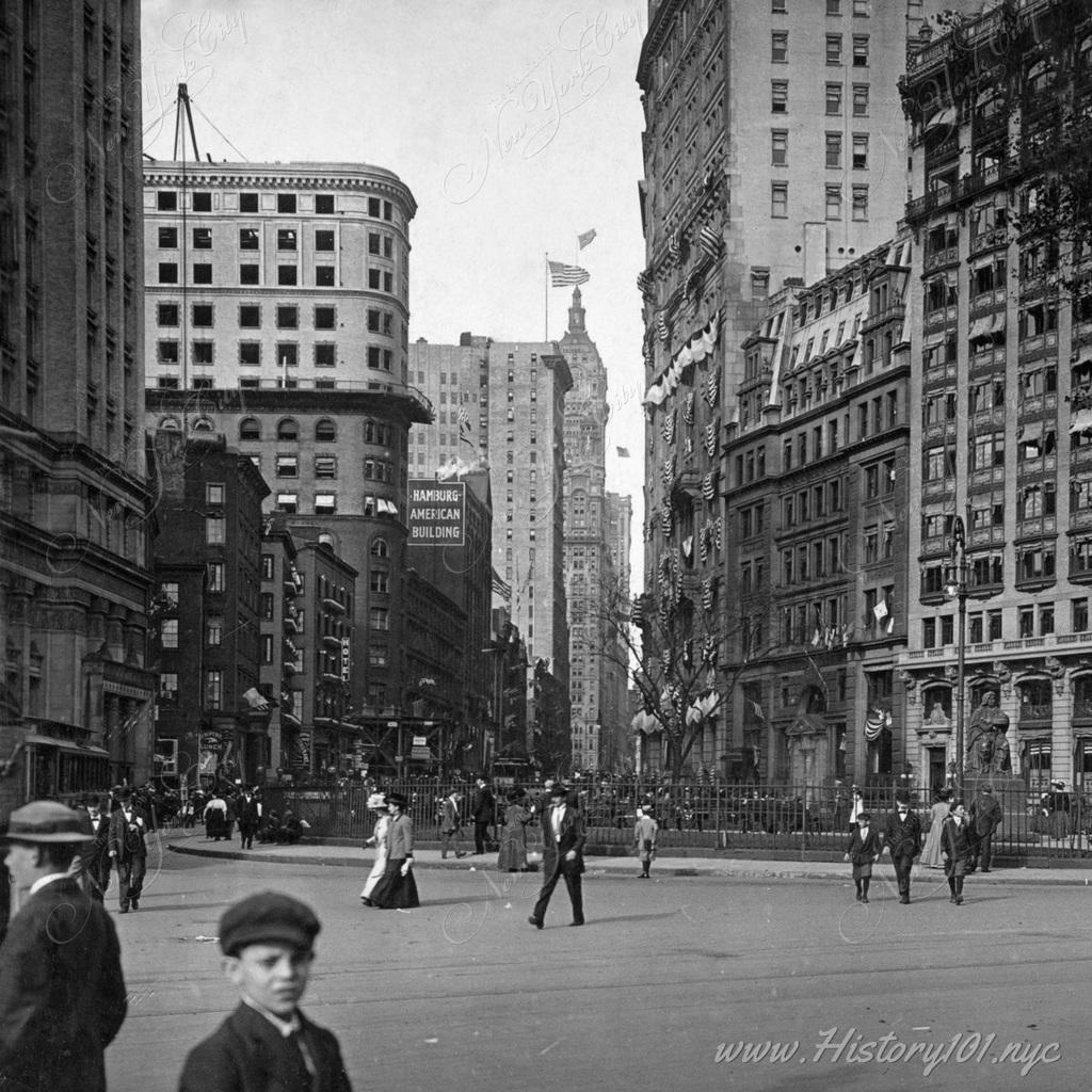 Photograph of a busy downtown street, Looking up Broadway from Custom House.
