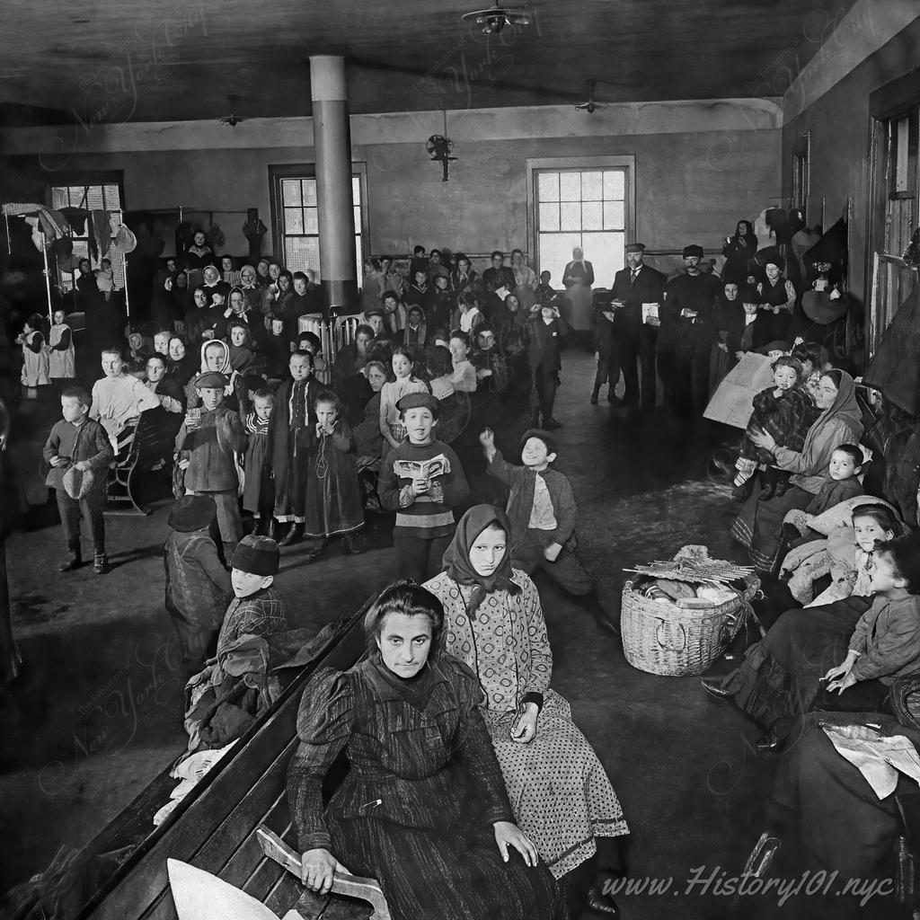 A photograph of the waiting room at Ellis Island, where recently arrived immigrants await examination.