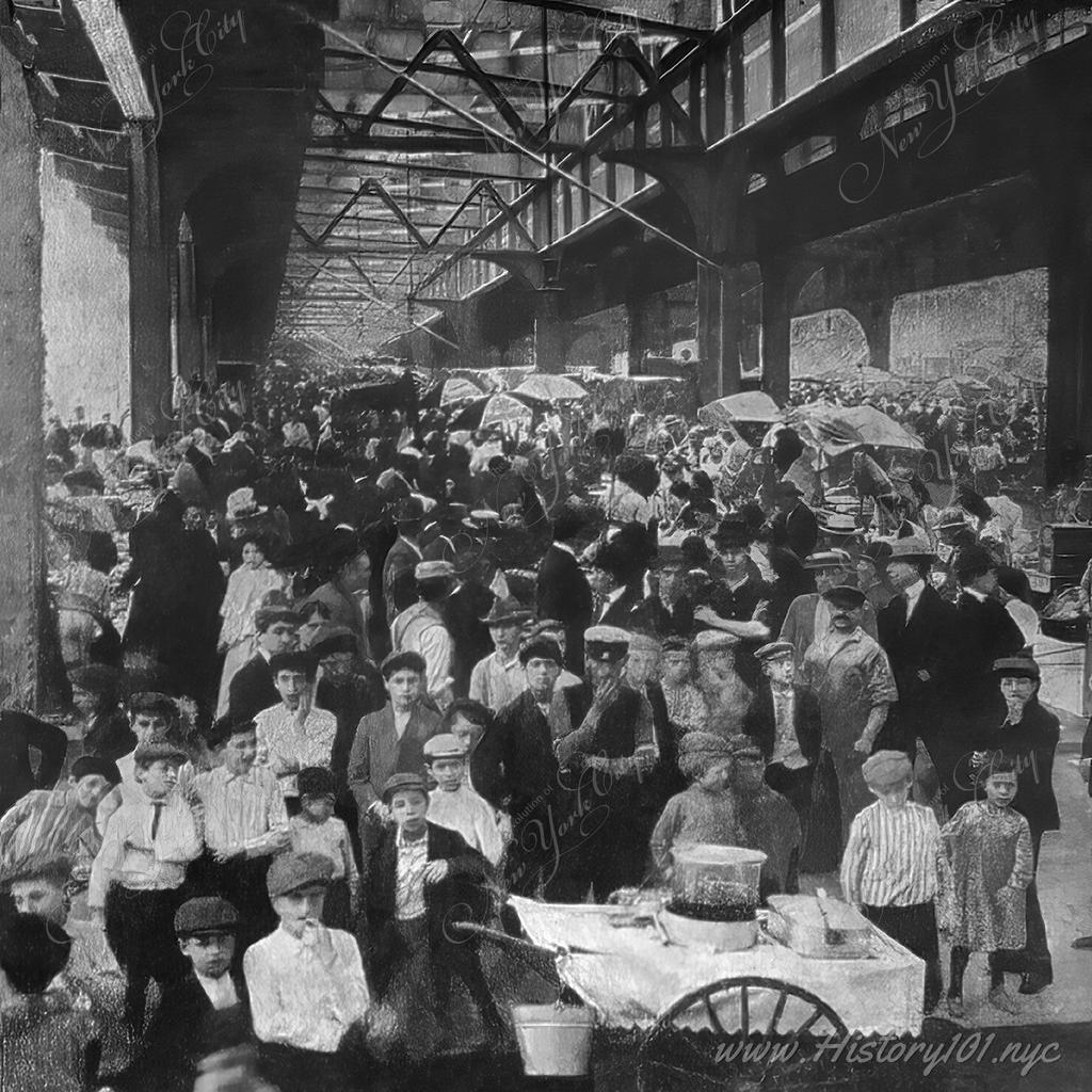 Photograph of  a bustling street market below the overpass of the Brooklyn Bridge