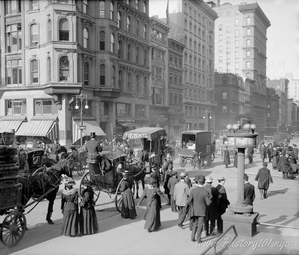 One of the city's busiest intersections filled with shoppers, commuters. The streets are packed with horses and carriages.