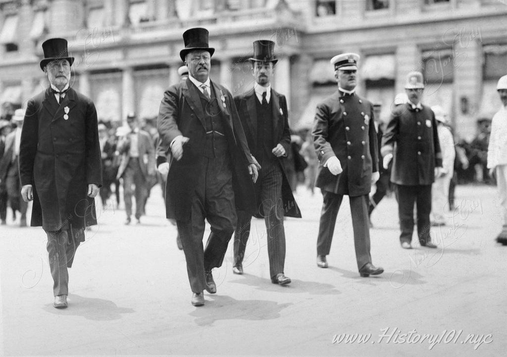 Theodore Roosevelt between Mayor Gaynor and Cornelius Vanderbilt, with hand outstretched to greet Rough Riders at a NYC parade thrown in his honor.