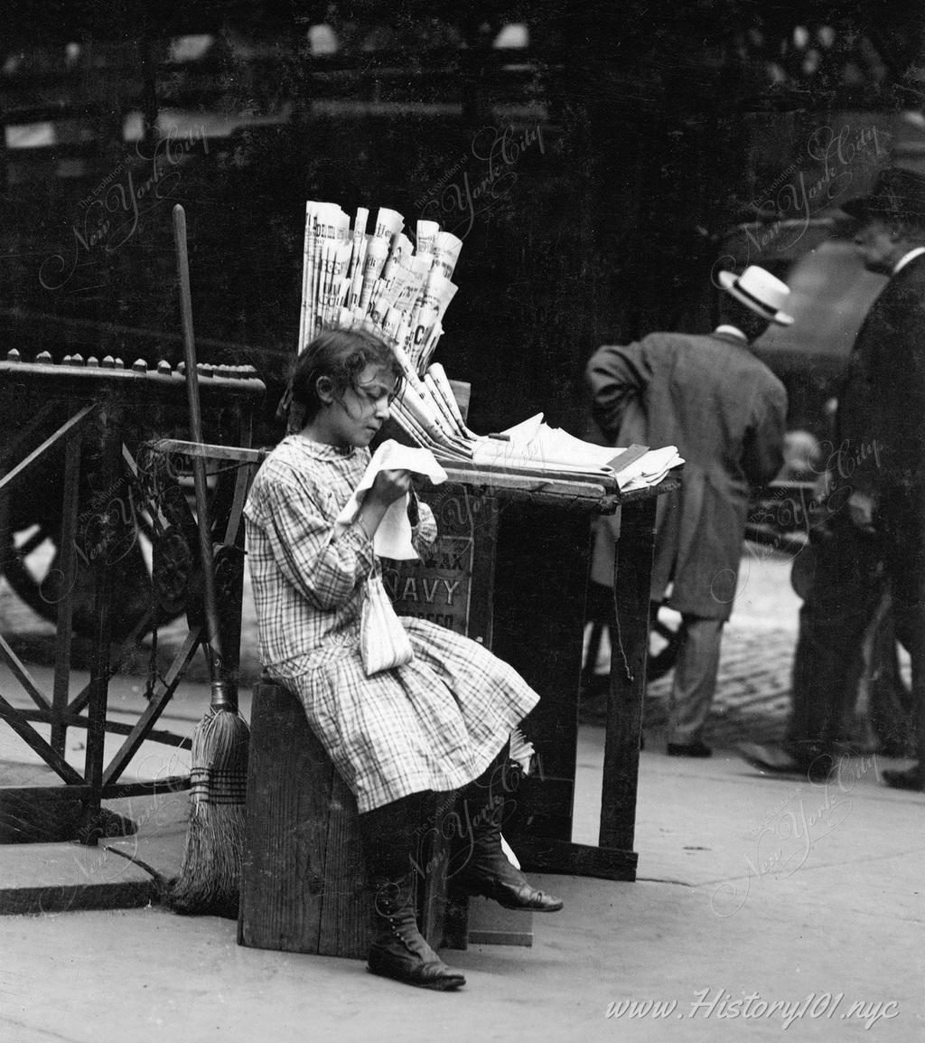 Photograph of Minnie Paster, a 10 year old having to work and tend a newspaper stand at Bowery & Bond