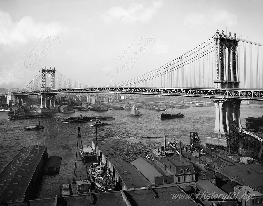 Photograph of the Manhattan Bridge, includes Brooklyn, the East River and downtown Manhattan.