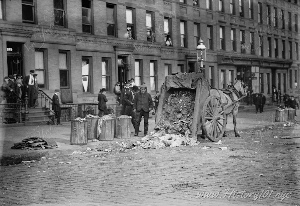 Photo shows a horse-drawn garbage wagon with its load dumped in the street during a New York City garbage strike which occurred from November 8-11.