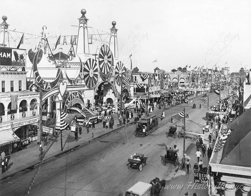 Photograph shows an overhead view of cars and trolleys making their way down Surf Avenue at the entrance to Coney Island's Luna Park.