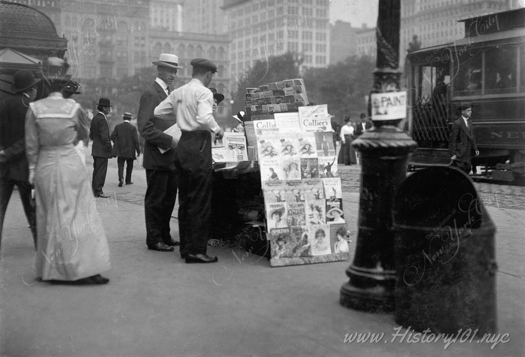 Photograph of a street vendor selling newspapers and magazines on Fifth Avenue near Madison Square Park.