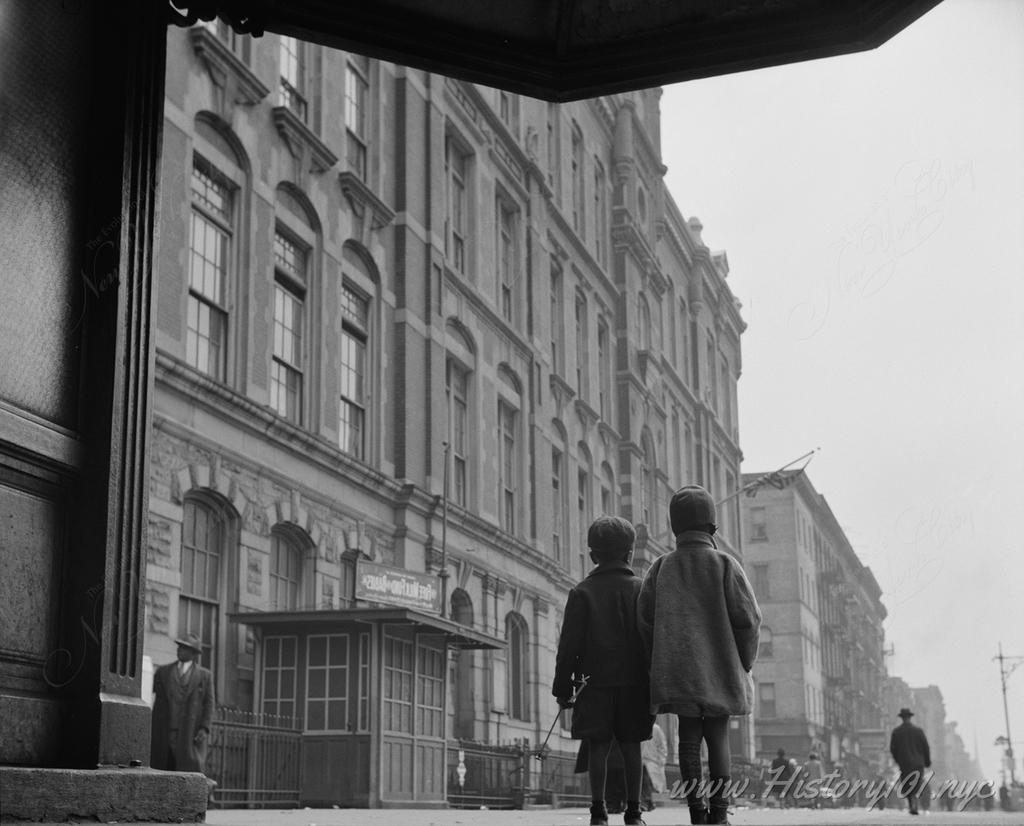 Photograph of pedestrians and brownstone buildings in Harlem.