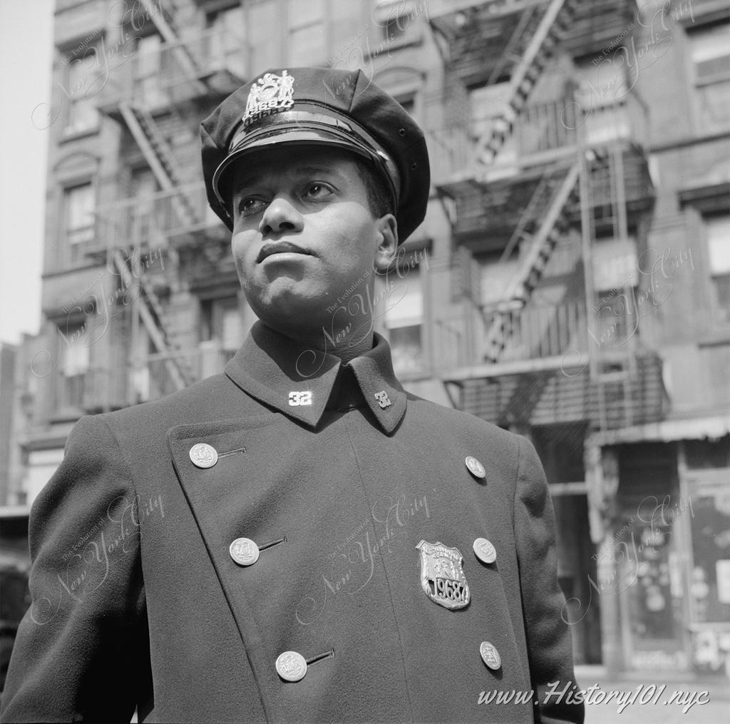 Photograph of a young police officer walking his beat in Harlem.