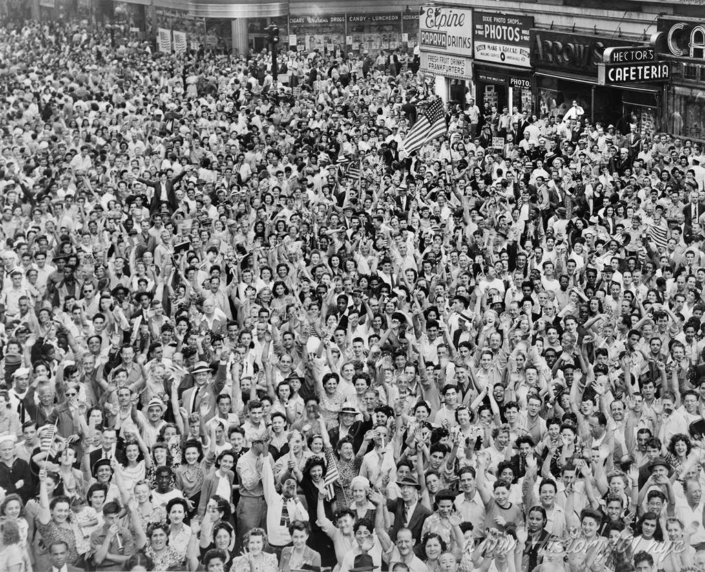 Crowd of people, many waving, in Times Square on V-J Day at time of announcement of the Japanese surrender in 1945.