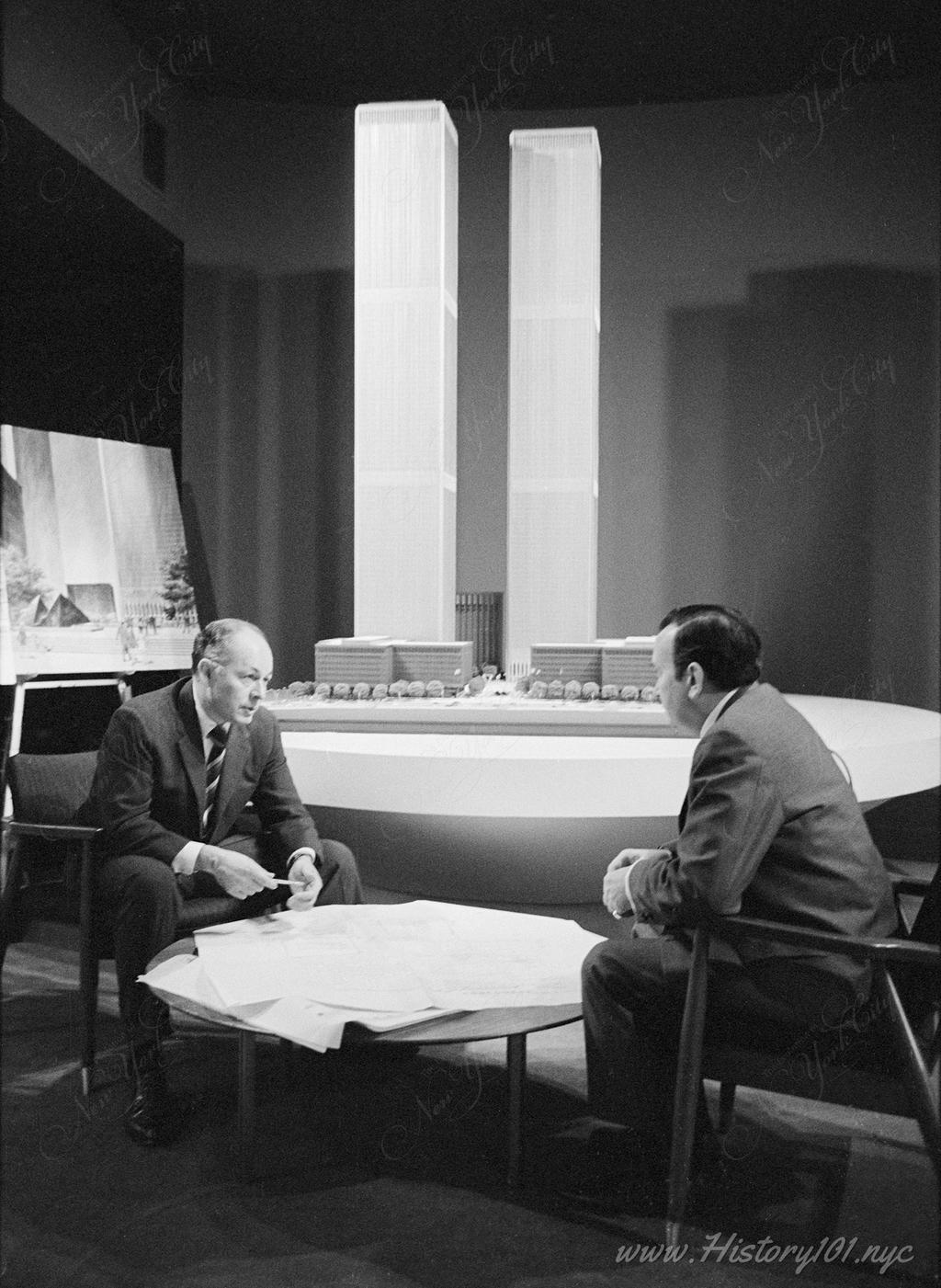 Officials of New York's Port Authority discussing office space with a scale model of New World Trade Center in background.