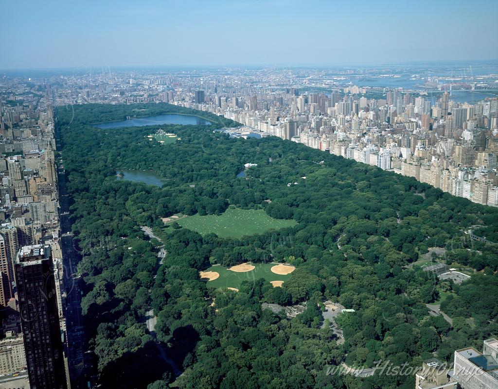 Discover Central Park's summer beauty in Carol M. Highsmith’s aerial photo, featuring lush landscapes, active basketball fields, and relaxing meadows with views extending to Harlem and The Bronx