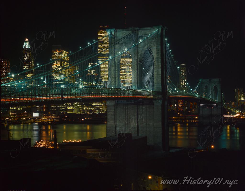 Photograph of the the Brooklyn Bridge and Downtown Manhattan skyline illuminated at night.