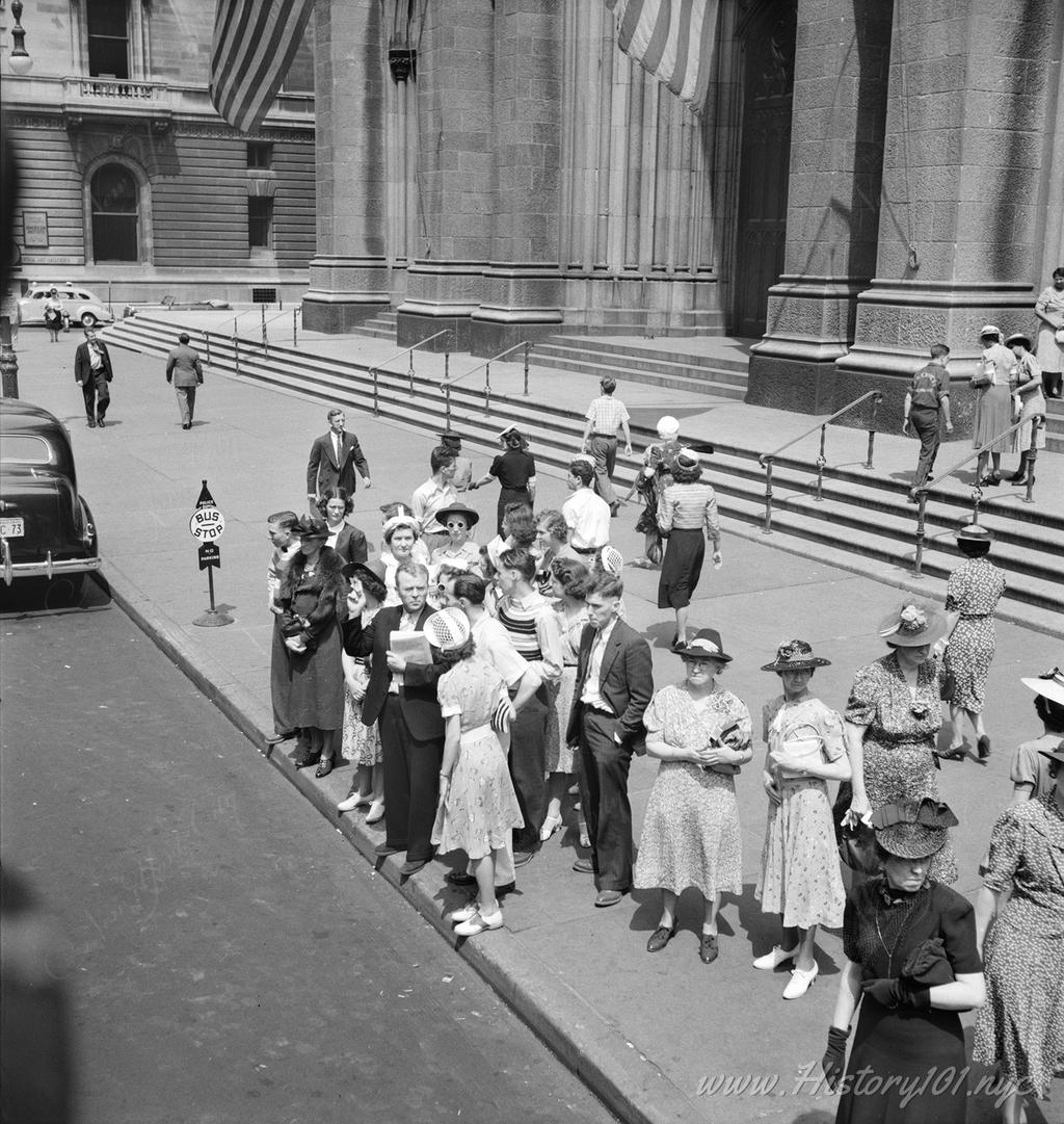 Photograph of New Yorkers waiting for an uptown bus in front of Saint Patrick's Cathedral.