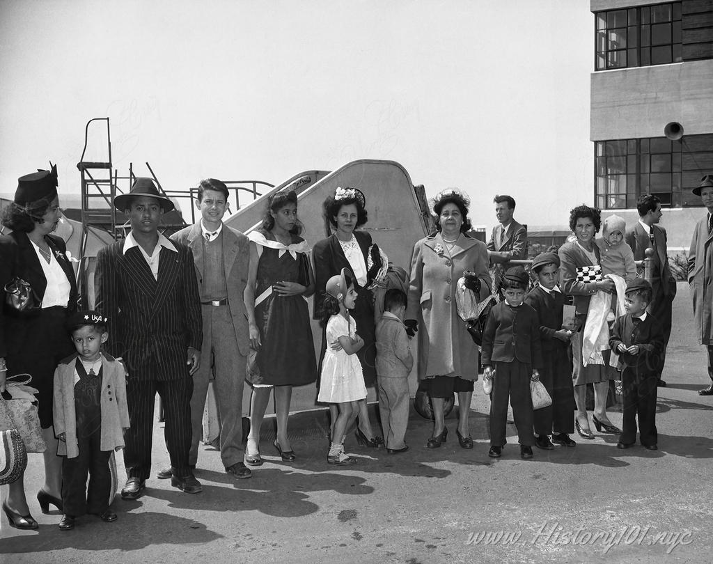 Photograph shows a group of Puerto Ricans, at Newark airport, who just arrived by plane from Puerto Rico waiting to be transported to New York.