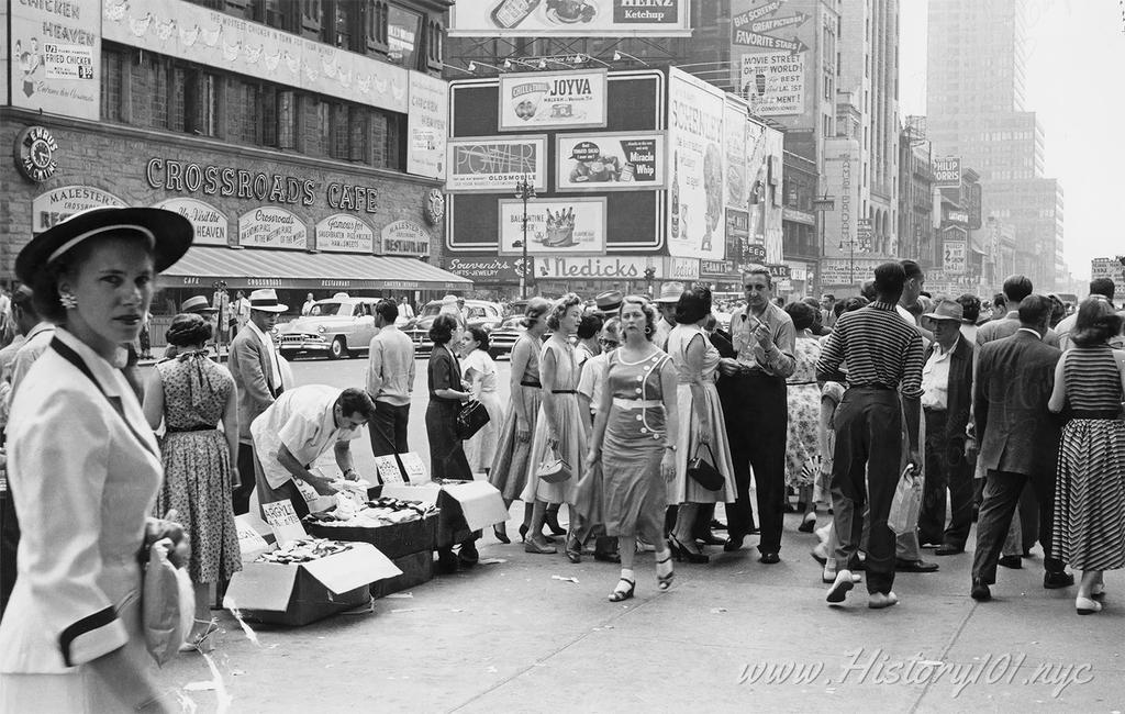 Photograph of Times Square showing advertisements and businesses such as the Crossroad's Cafe and Nedicks.