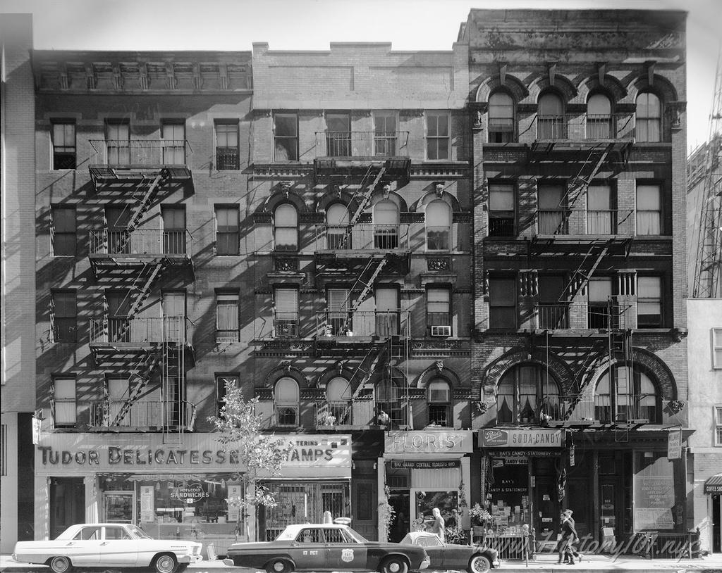 Photograph firectly across the street from buildings and cars parked on Second Avenue.