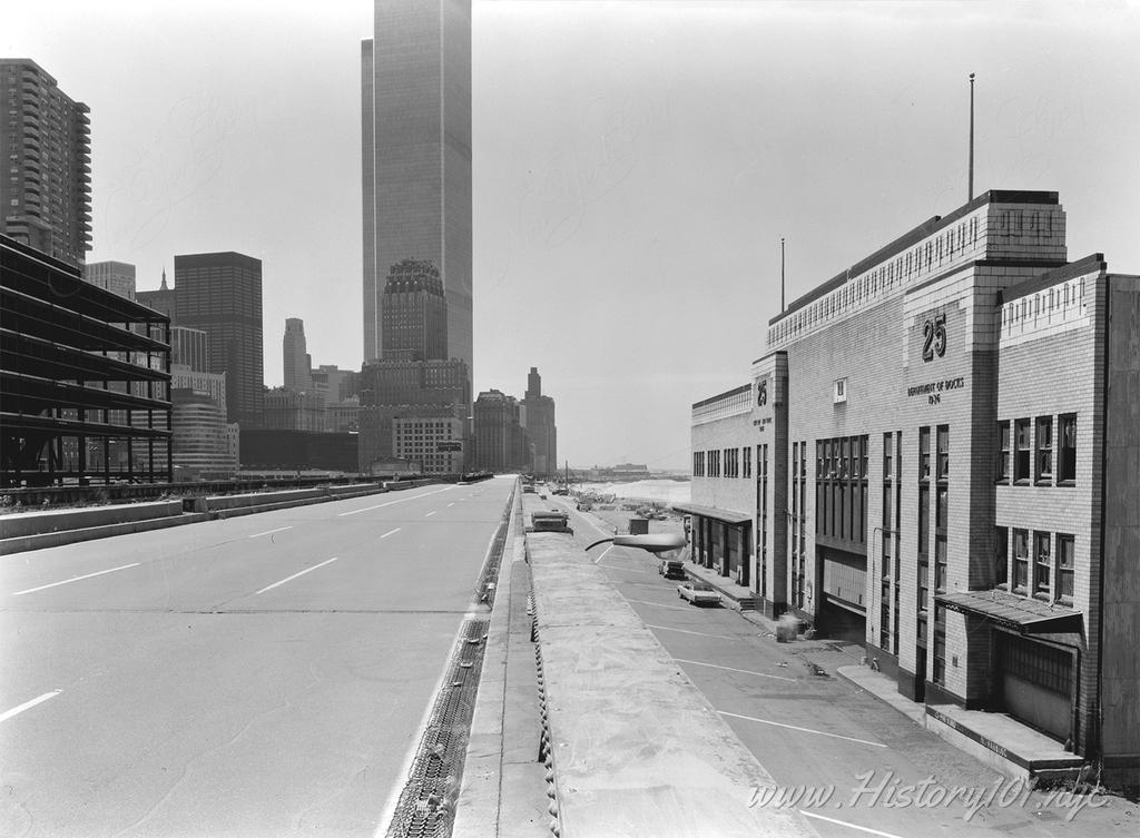 Photograph looking south on Westside Highway at Pier 25, with the World Trade Center visible in the distance.