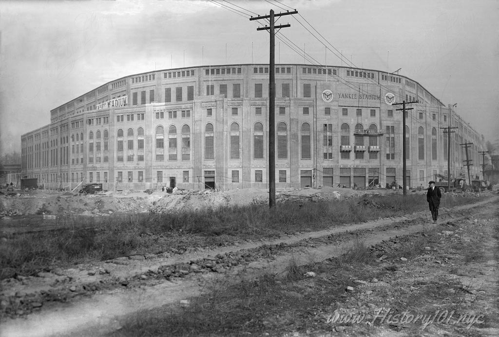 Photograph of Yankee Stadium with a lone figure walking towards the camera.