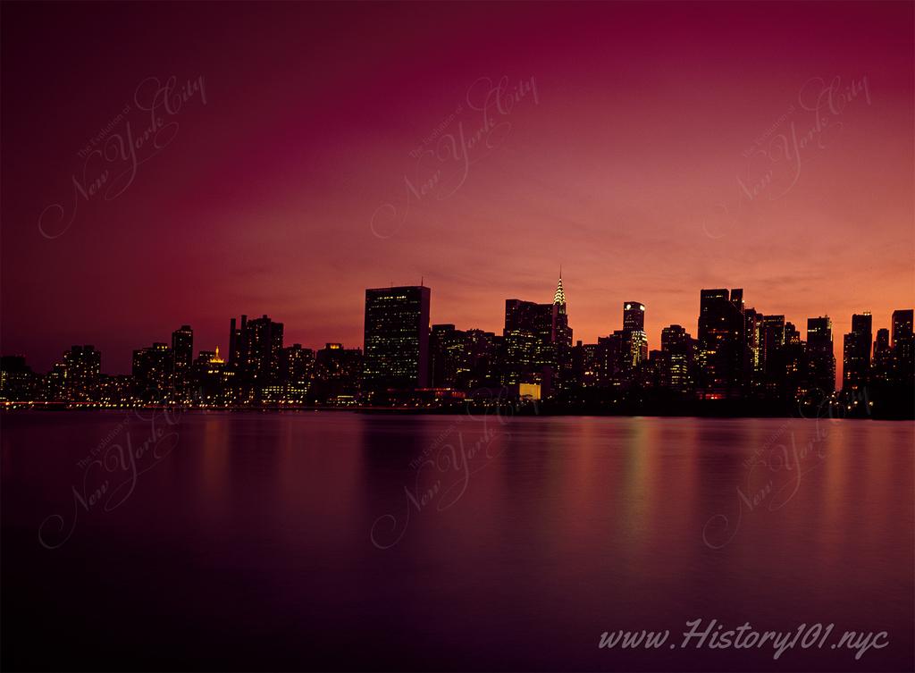 Photograph of Manhattan's midtown skyline at dusk under a reddening sky.