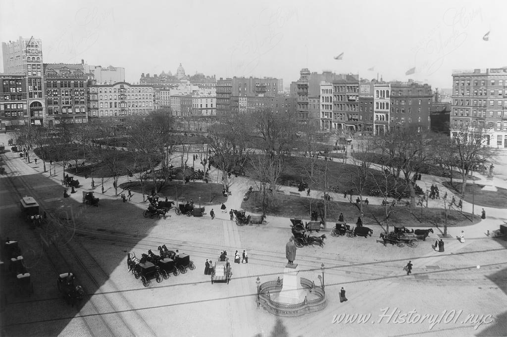 Aerial photograph above Union Square filled with people and horses and the Lincoln Statue in the foreground.