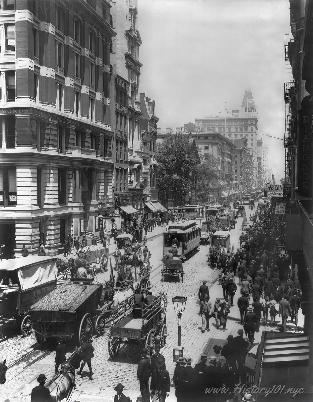 Photograph of Broadway near John Street filled with carriages and pedestrians.