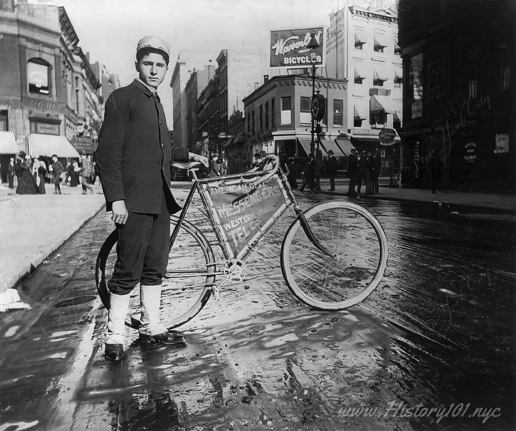 Photograph of a young messenger posing with his bicycle.