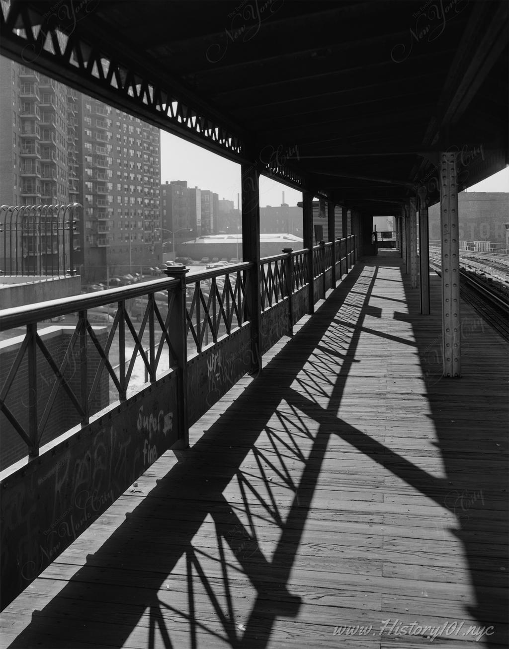Explore a 1986 photograph of the 169th Street Station on the IRT Third Avenue Elevated Line in the Bronx, capturing the historic wooden platform and surrounding cityscape