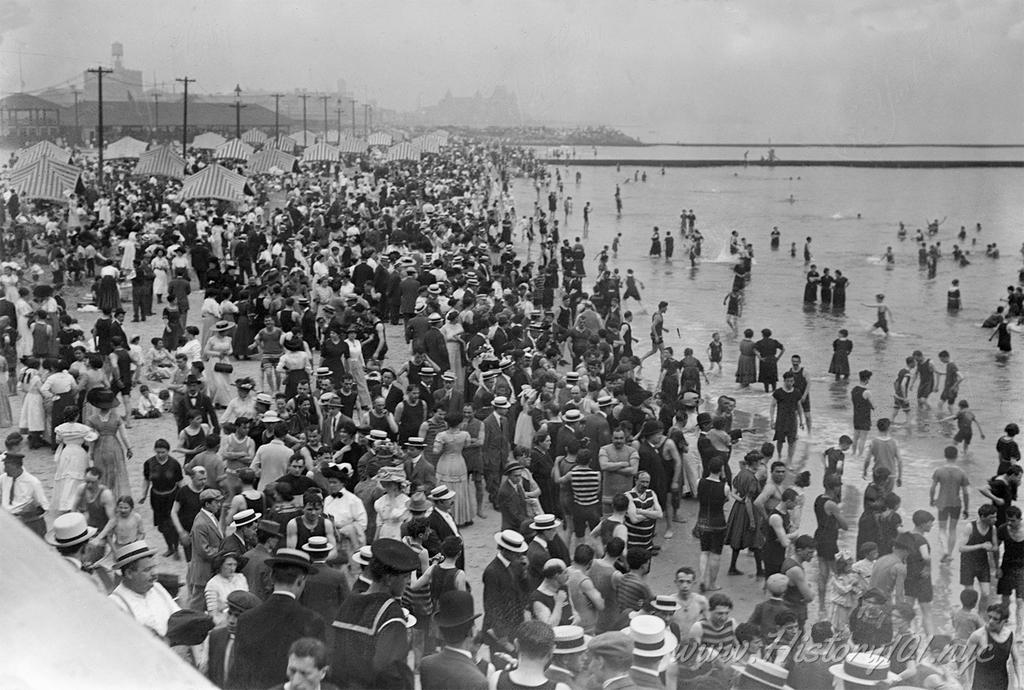 Photograph of crowds celebrating the Fourth of July on the shores of Coney Island.