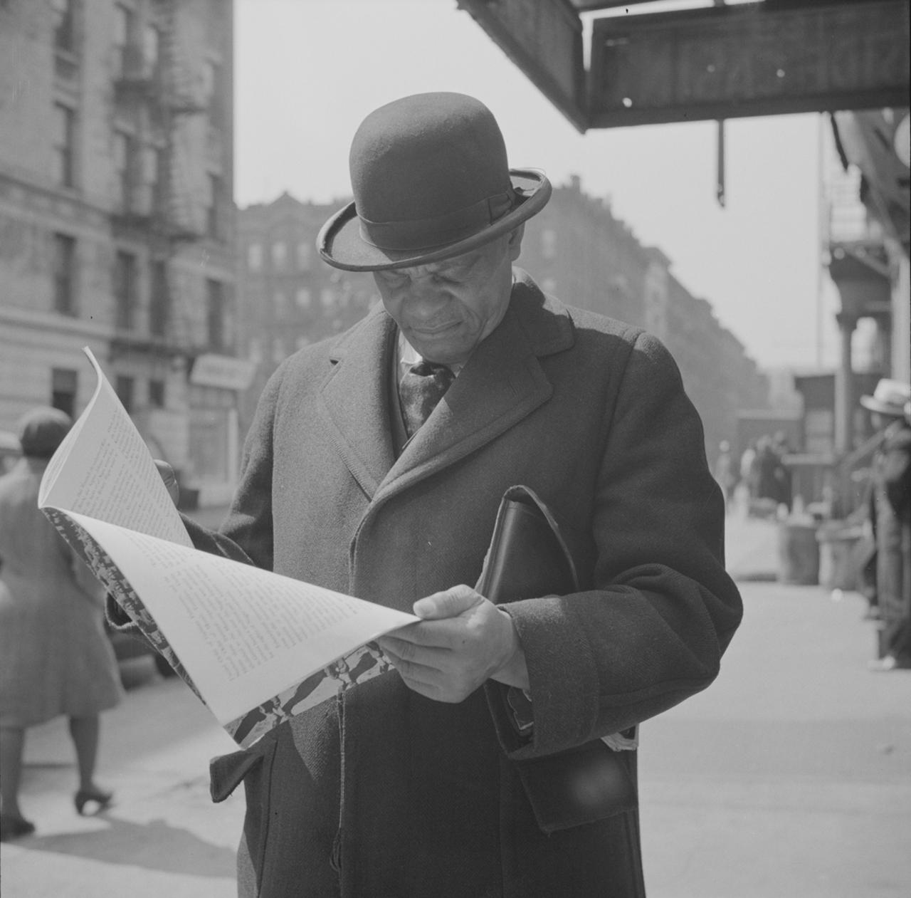Man Reading a Newspaper on Harlem Street NYC in 1943