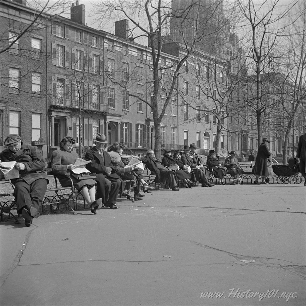 Photograph of people sitting on benches at Washington Square Park.