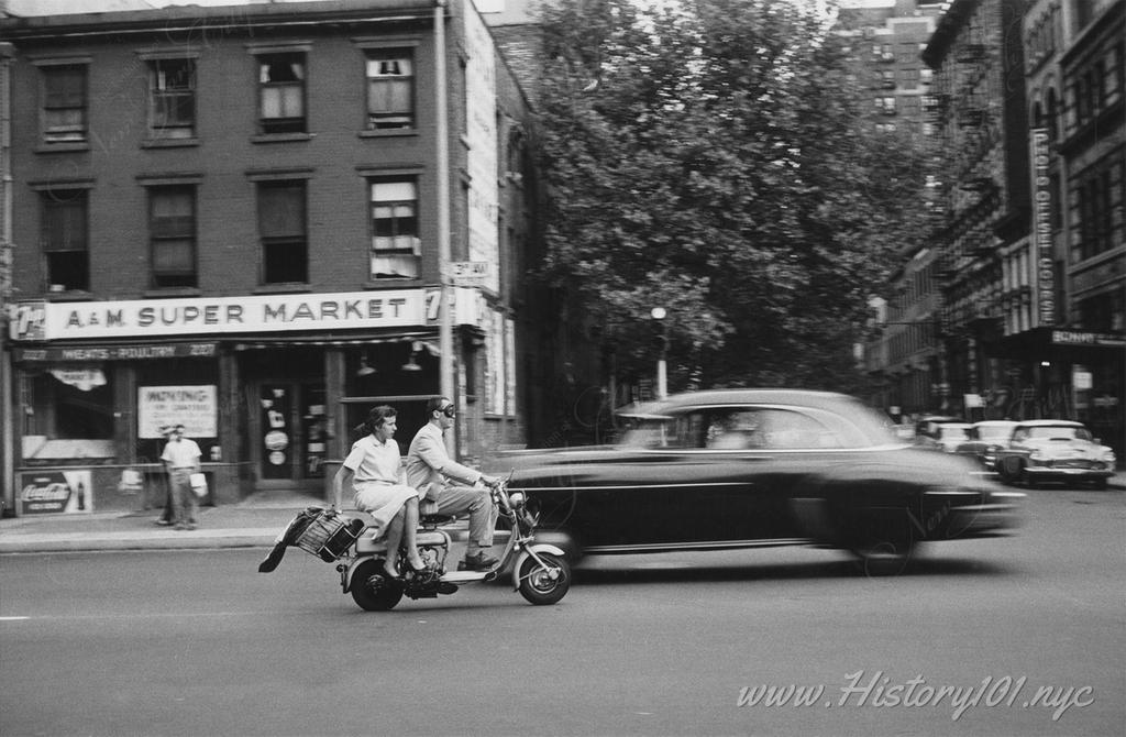 Photograph of a man and woman zipping along Third Avenue on a scooter.