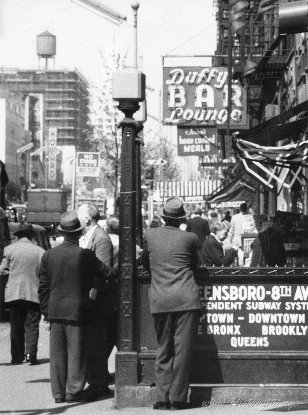 Explore Angelo Rizzuto's 1957 photo of New Yorkers gathered near the 8th Avenue subway entrance, with Duffy's Bar Lounge in the background, capturing midtown Manhattan life