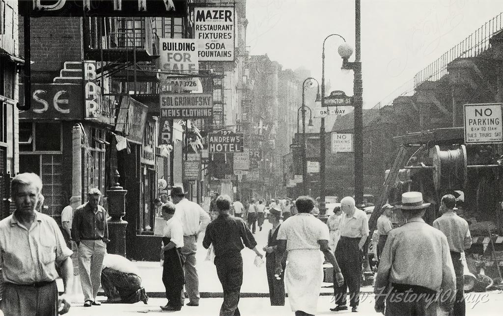 Photograph of Rivington Street bustling with pedestrians against a backdrop of business signs and the local elevated railroad.