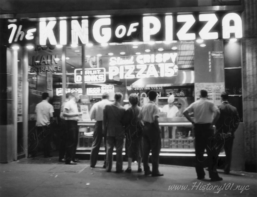 Photograph of customers lined up for a slice at The King of Pizza.