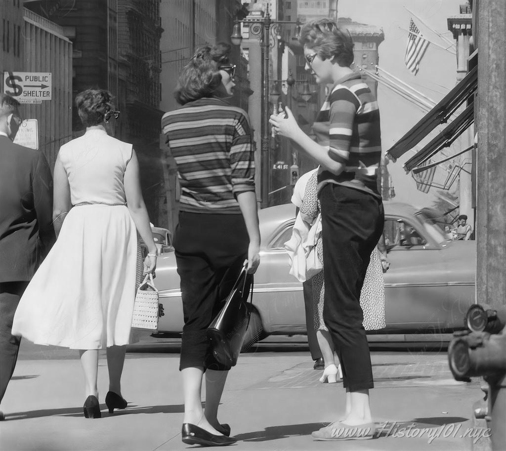 Photograph of two women in striped sweaters chatting on a sidewalk corner near East 41st Street.