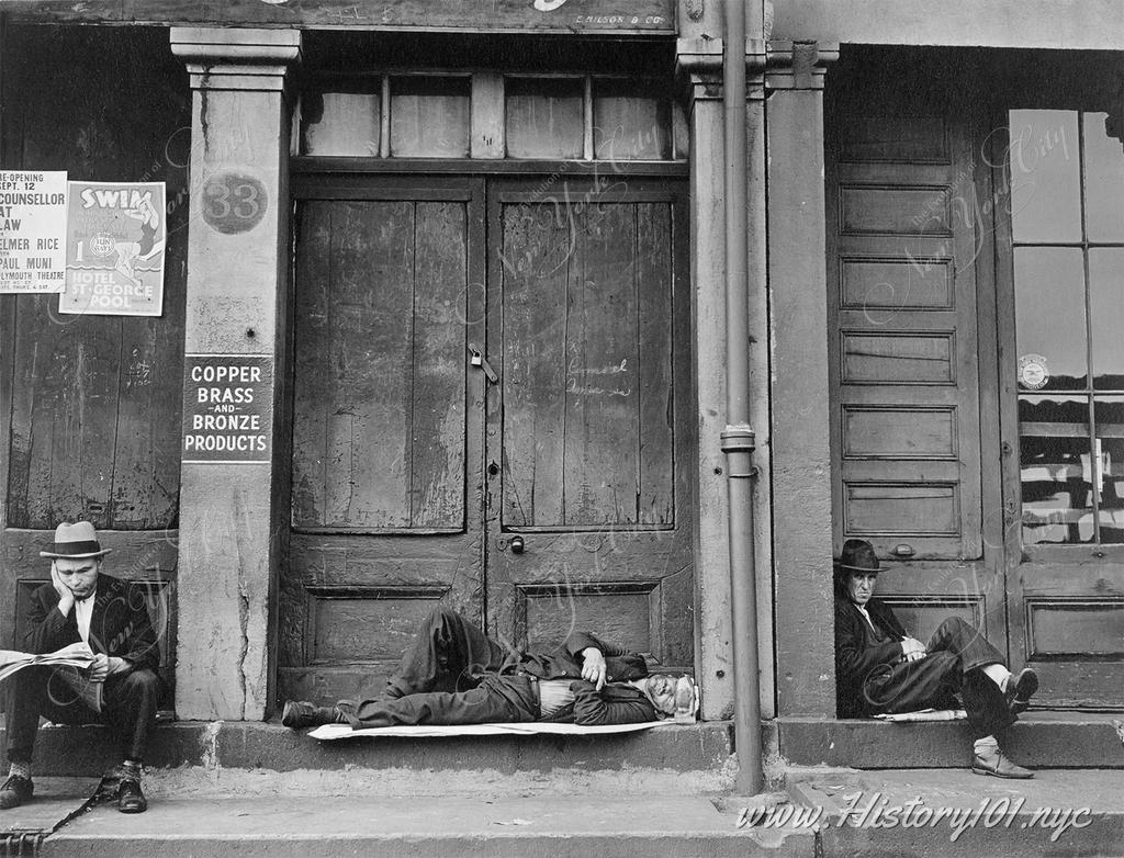 Photograph of men sleeping in the doorways of South Street's storefronts at the height of the Great Depression - an era of poverty as the city endured widespread unemployment and homelessness.