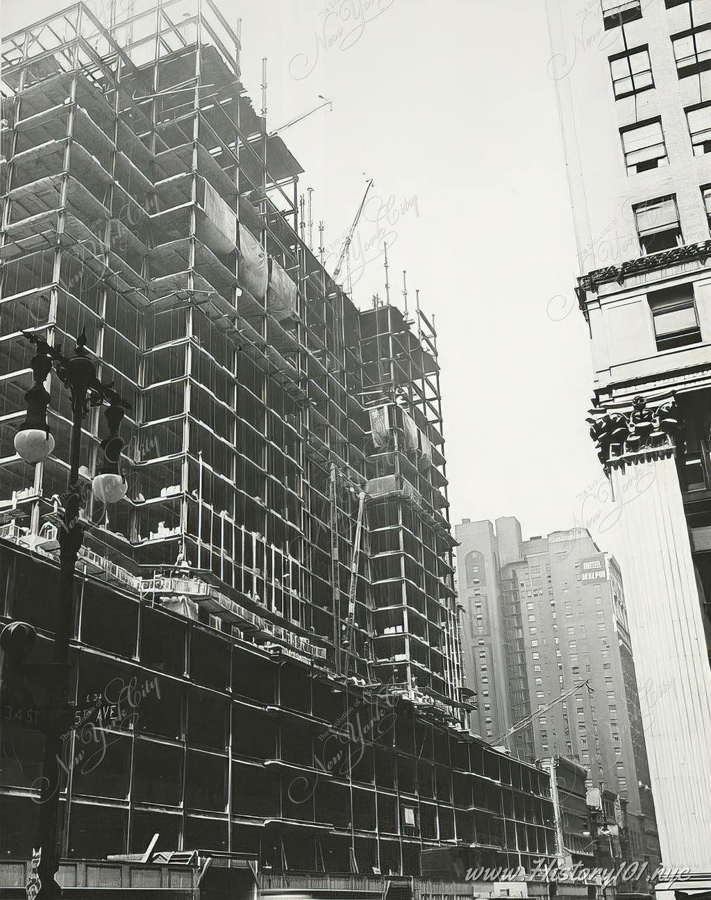The first twenty floors of the Empire State Building are being constructed. There is no visible facade yet, only the steel beam structure and scaffolding of construction workers.