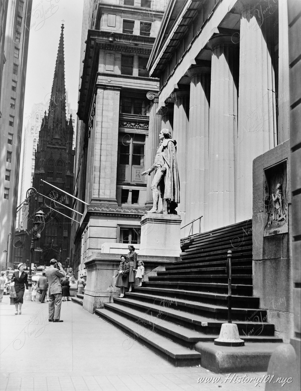 A woman poses with two small children in front of the side entrance of US Custom House in downtown Manhattan