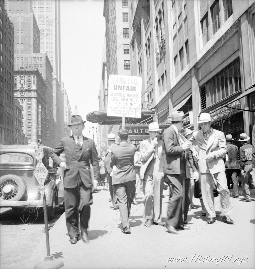 Photograph of a busy street scene, looking north towards 35th Street from the 7th Avenue entrance of Macy's department store.